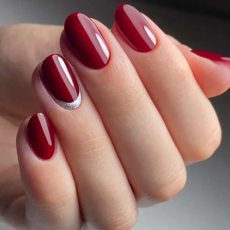 Unhas vermelhas escuras decoradas com brilho prata na filha única como francesinha invertida 