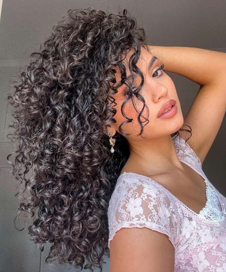 Corte repicado longo cacheado preto com franja na altura do queixo