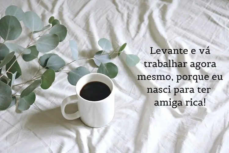 Foto de caneca com café sobre cama branca e frase: Levante e vá trabalhar agora mesmo, porque eu nasci para ter amigo(a) rico(a)