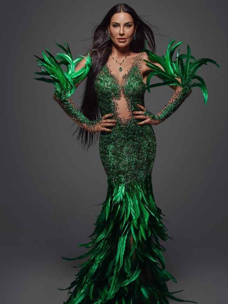 Cintia Chagas, professora, com fantasia verde esmeral de plumas e pedras comportada no Carnaval 2023.