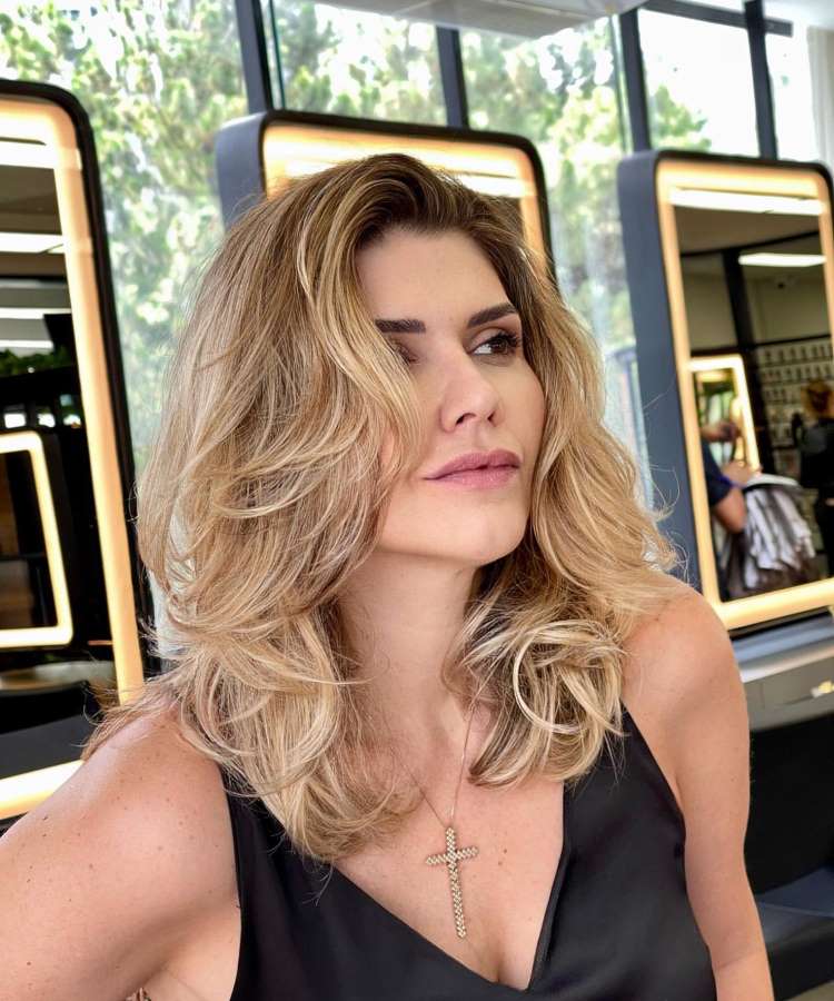 Corte repicado longo liso escovado loiro com franja na altura da boca
