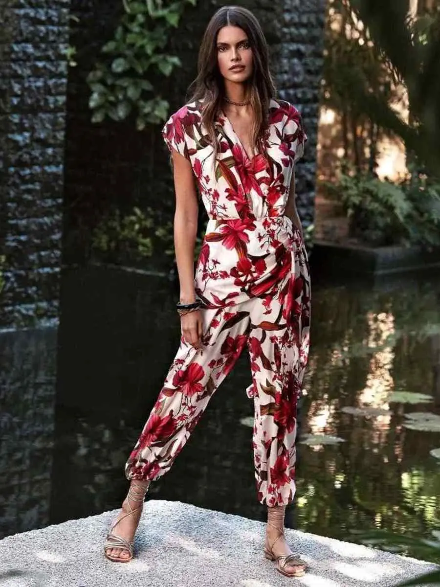 Mulher usando look vermelho floral para o Natal composto por macacão.