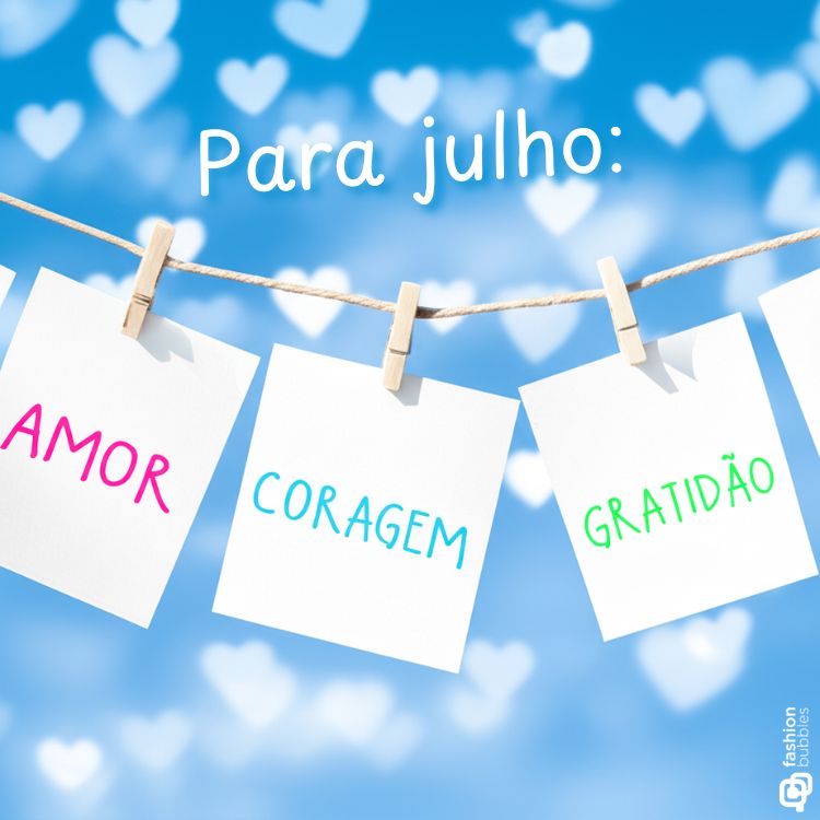 A imagem exibe três bilhetes brancos pendurados em um varal com pregadores de roupa. Em cada bilhete, estão escritas as palavras "AMOR", "CORAGEM" e "GRATIDÃO". Acima, a frase "Para julho:" flutua em um fundo azul com corações brancos desfocados.

