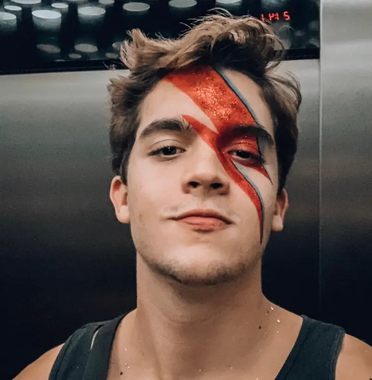 Selfie de homem de pele clara com maquiagem característica do David Bowie