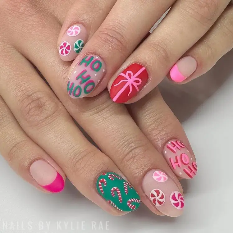 mãos com unhas em formato amendoado com decoração natalina