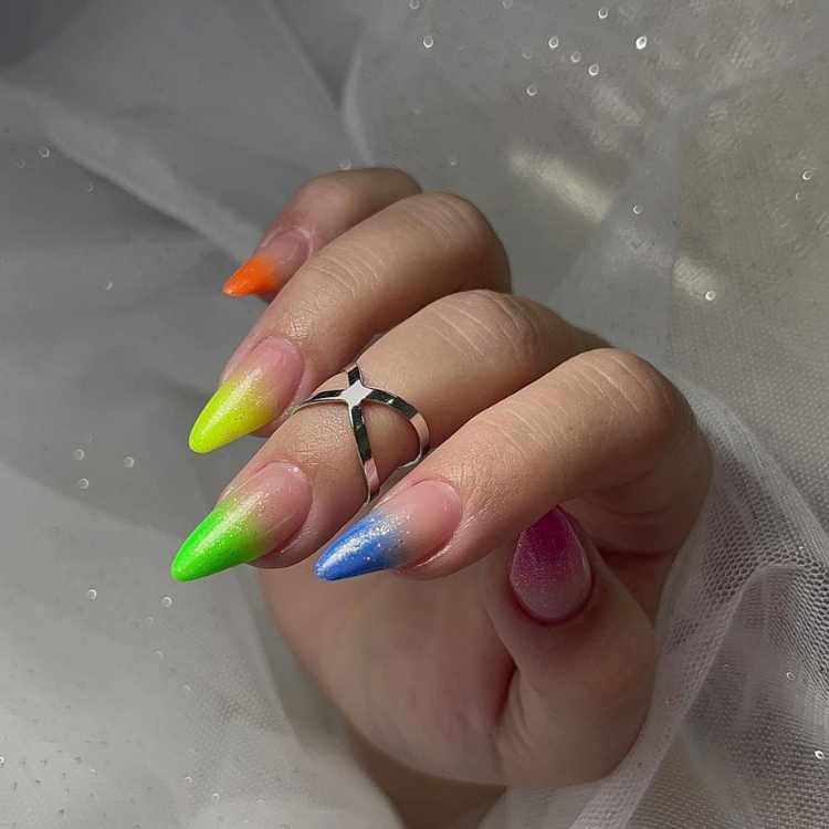 Unhas coloridas decoradas com glitter.