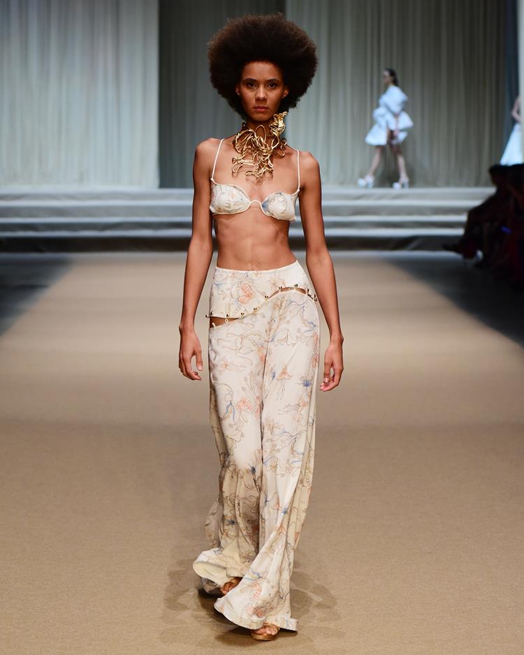 modelo com conjunto de top e calça brancos estampados.
