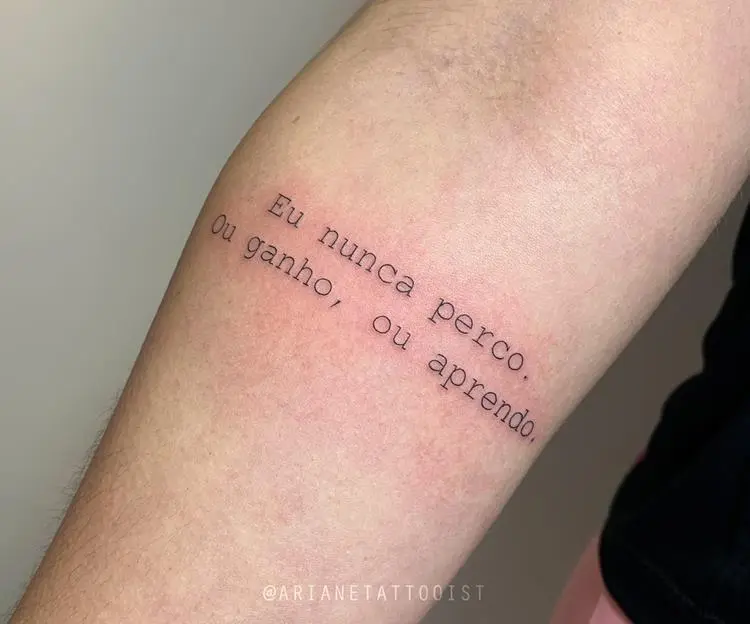 tatuagem escrita Eu nunca perco. Ou ganho, ou aprendo no braço