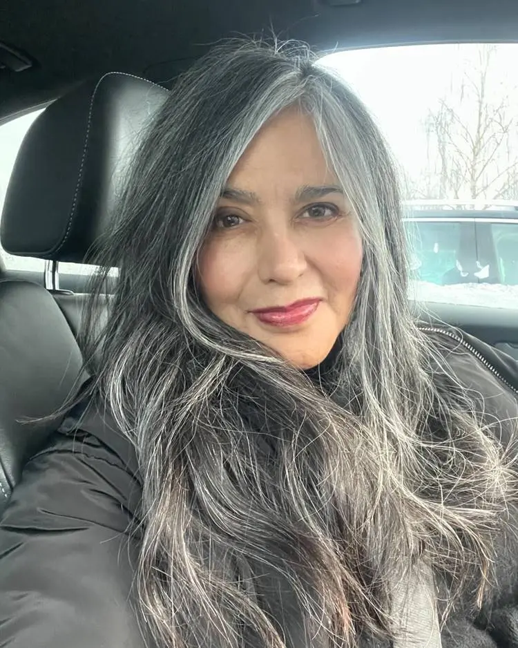Mulher em carro com cabelos grisalhos