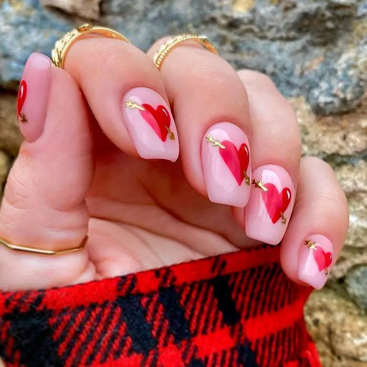 Unhas decoradas com corações vermelhos cupido