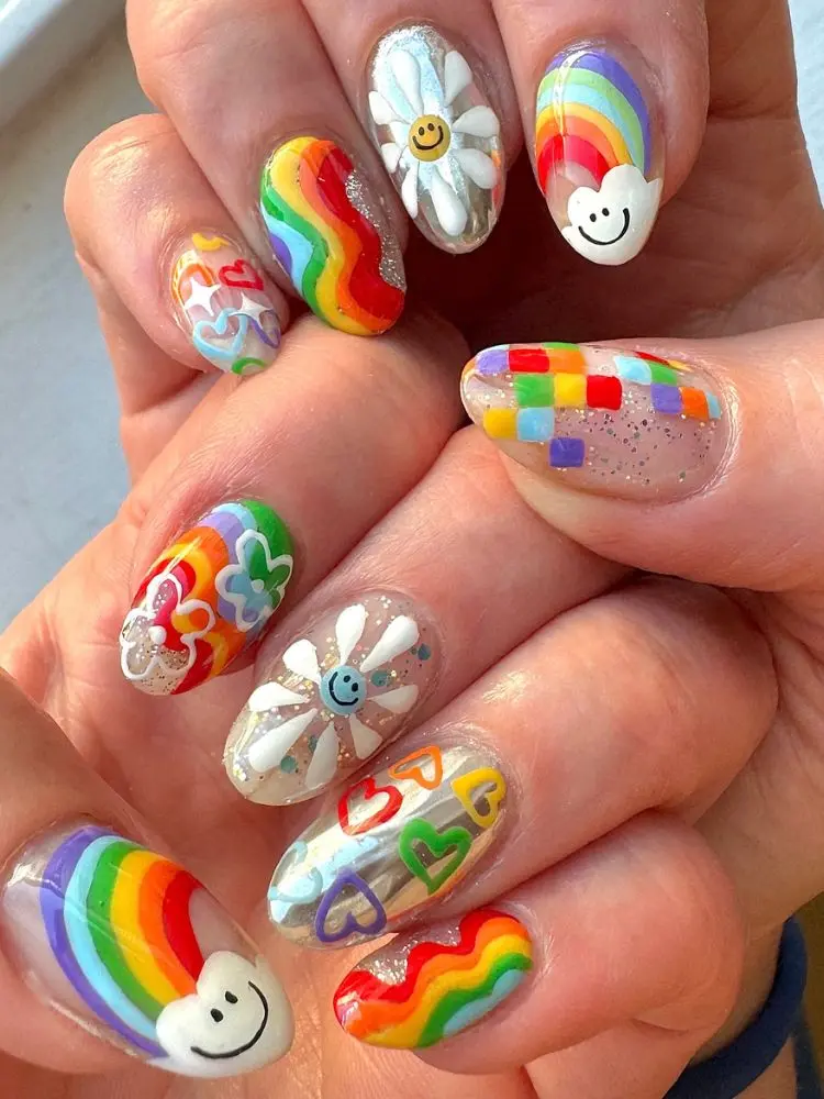 Unhas redondas com desenhos maximalistas em tons de arco-íris, como flores, corações, ondas, etc