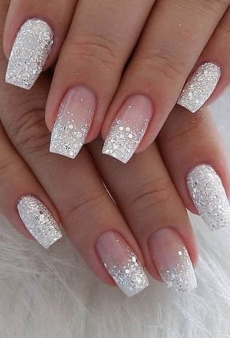 Unhas quadradas médias com glitter prata nas pontas do anelar e médio, e glitter prata em toda a unha do mindinho e indicador 