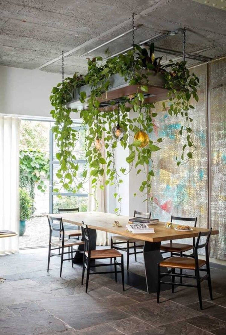 Sala com mesa grande de madeira e jardim no teto 