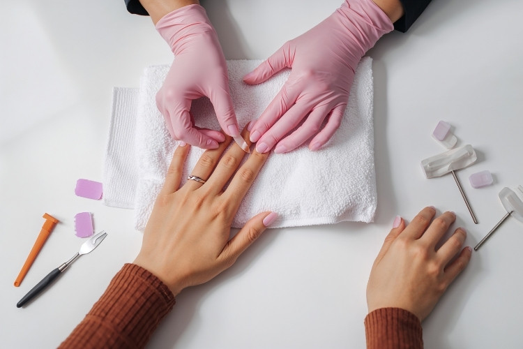 Foto de manicure fazendo as unhas de cliente