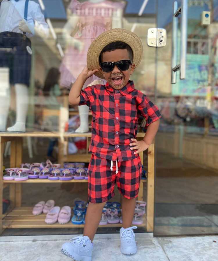 Garoto com look moderno xadrez vermelho para festa junina