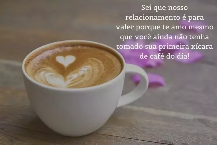 Foto de xícara branca de café com flores roxas ao fundo e frase: Sei que nosso relacionamento é para valer porque te amo mesmo que você ainda não tenha tomado sua primeira xícara de café do dia!