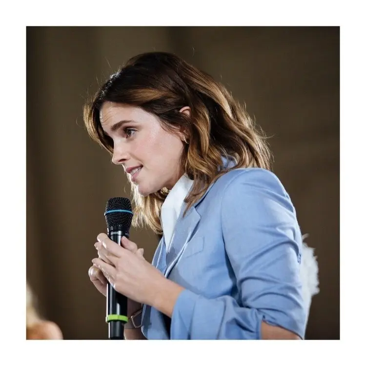 Emma Watson de terno azul falando ao microfone 