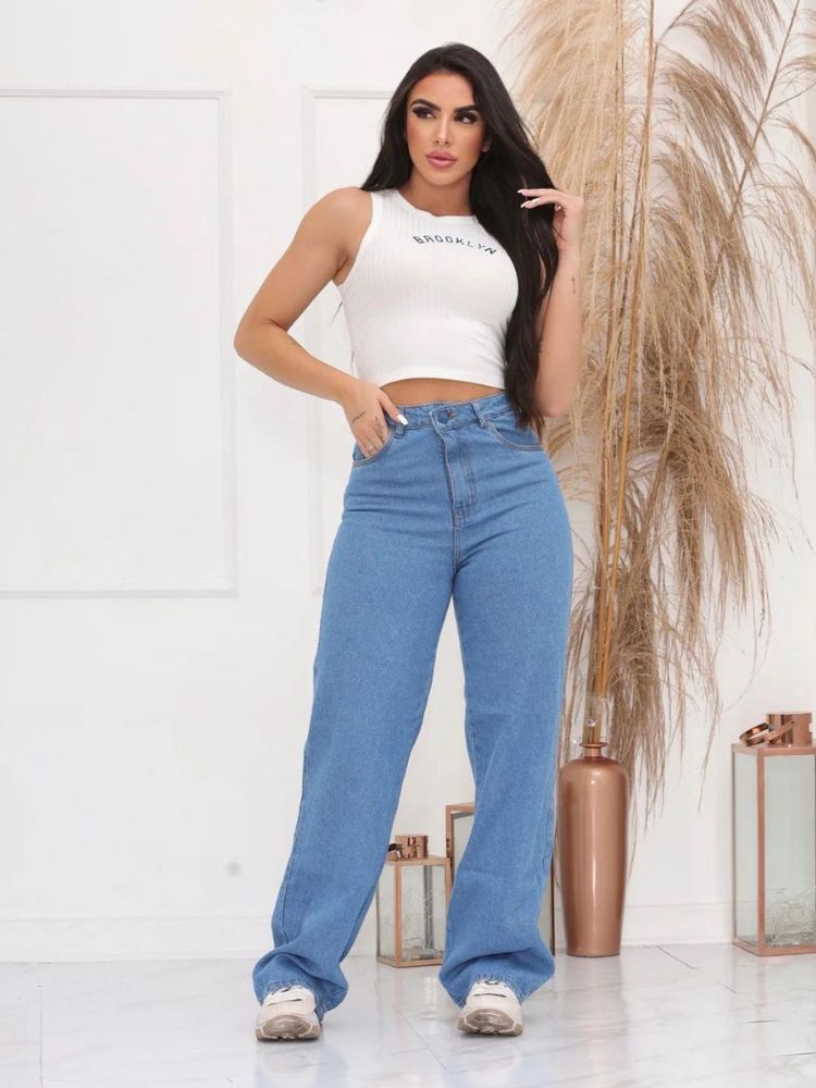 Mulher de pele clara com calça jeans cintura alta e cropped branco
