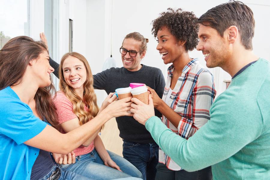Grupo de amigos brindando com copos de café.