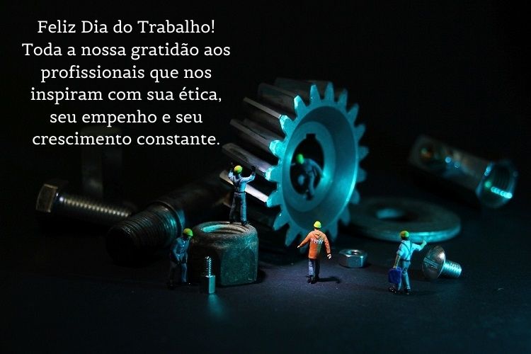 Foto de engrenagens grandes com bonecos pequenos e frase "Feliz Dia do Trabalho! Toda a nossa gratidão aos profissionais que nos inspiram com sua ética, seu empenho e seu crescimento constante."