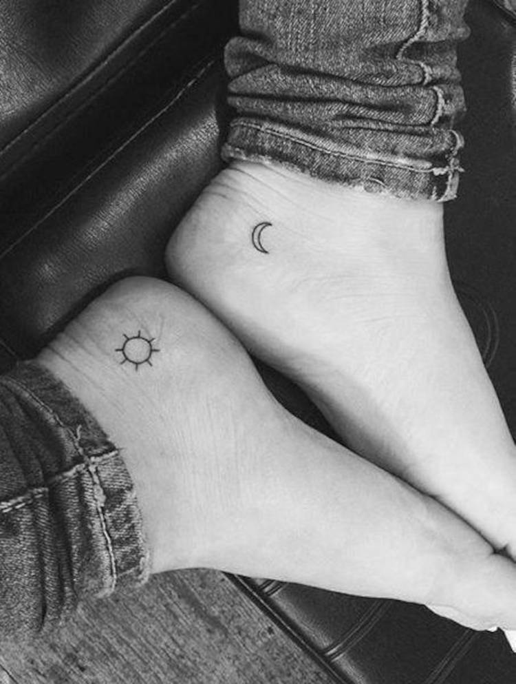 Pés juntos com sol tatuado em um e lua no outro 
