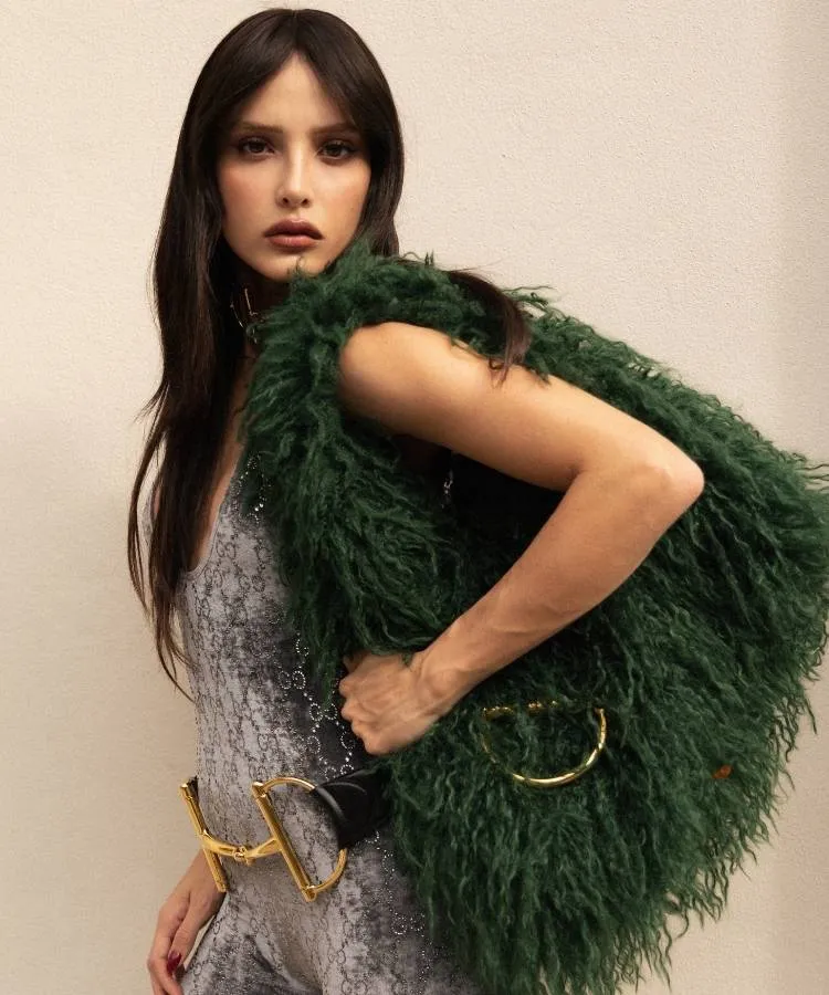 Influencer usando macacão cinza e blusa verde de pelúcia