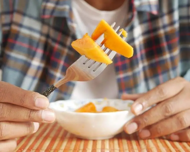 Foto de pessoa segurando garfo com o fruto.