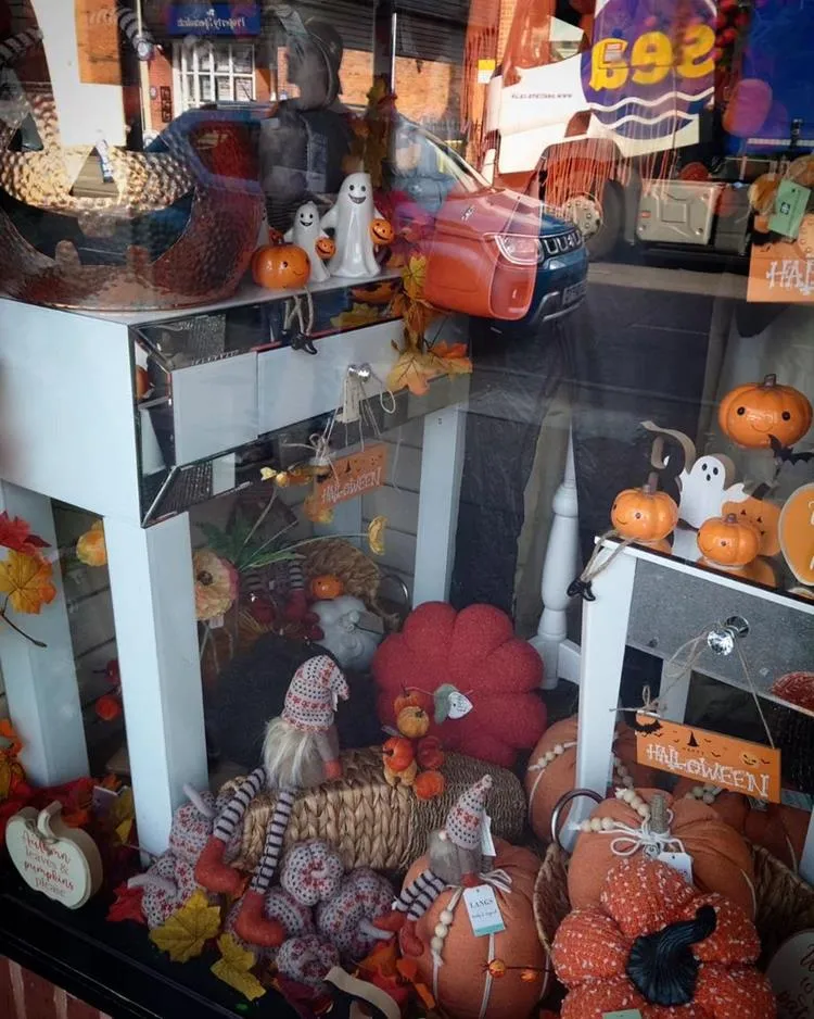 Vitrine com decorações de Halloween, como fantasmas e abóboras de porcelana, madeira, pelúcia e crochê