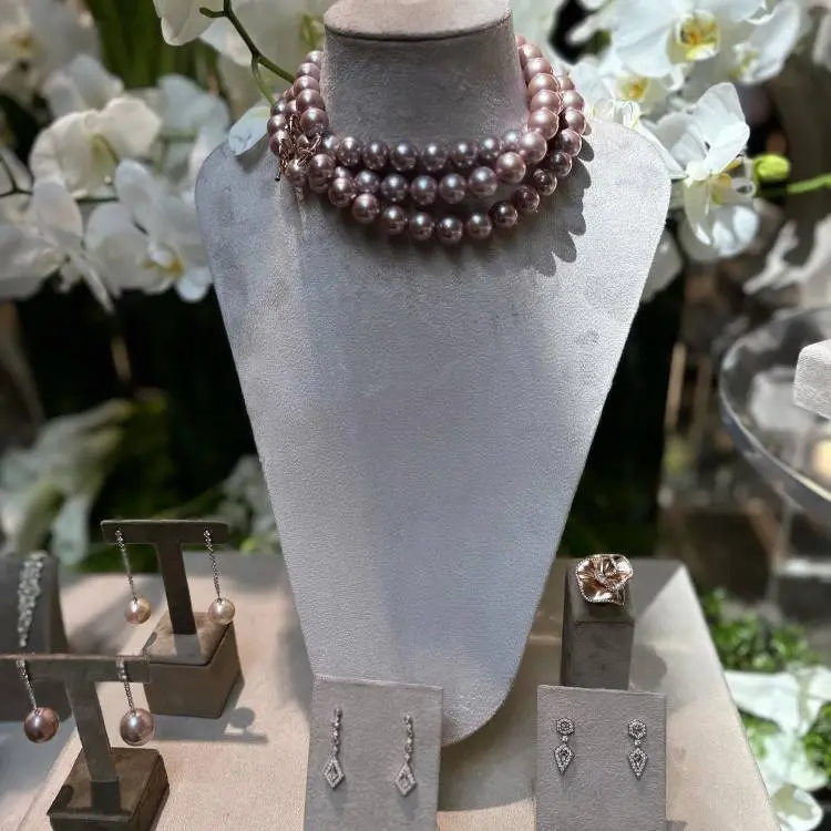 Exposição de joias com colar e brincos de pérolas, anel ou broche de flor e brincos de diamantes