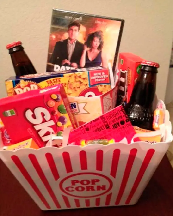 Cesta de balde de pipoca com pipoca, cerveja, DVD e docinhos