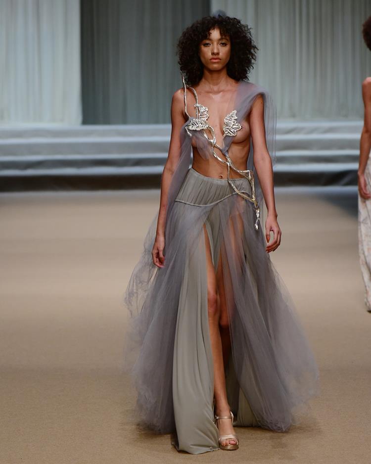 modelo com vestido cinza longo com fendas.
