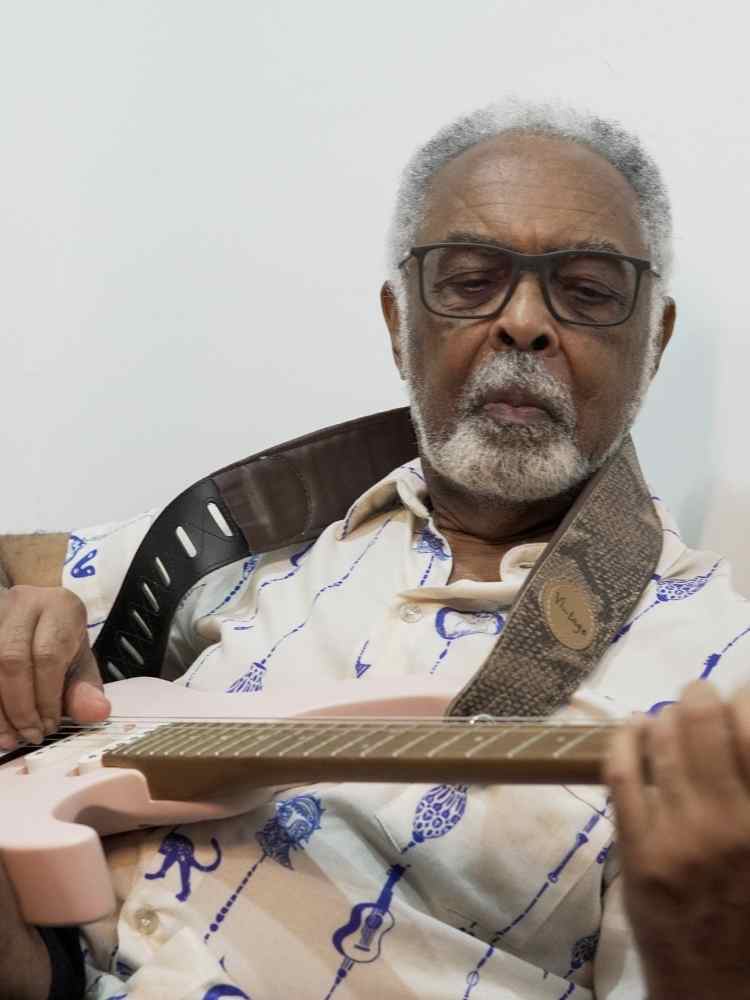 Gilberto Gil tocando guitarra.