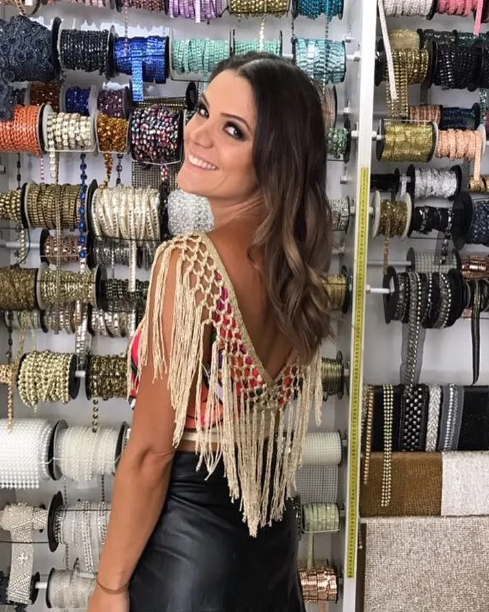 Mulher de pele clara com abada customizado com macramê e saia preta