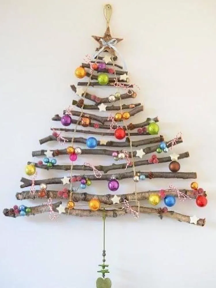 Árvore de Natal feita com galhos na parede e enfeitada com bolinhas coloridas. 