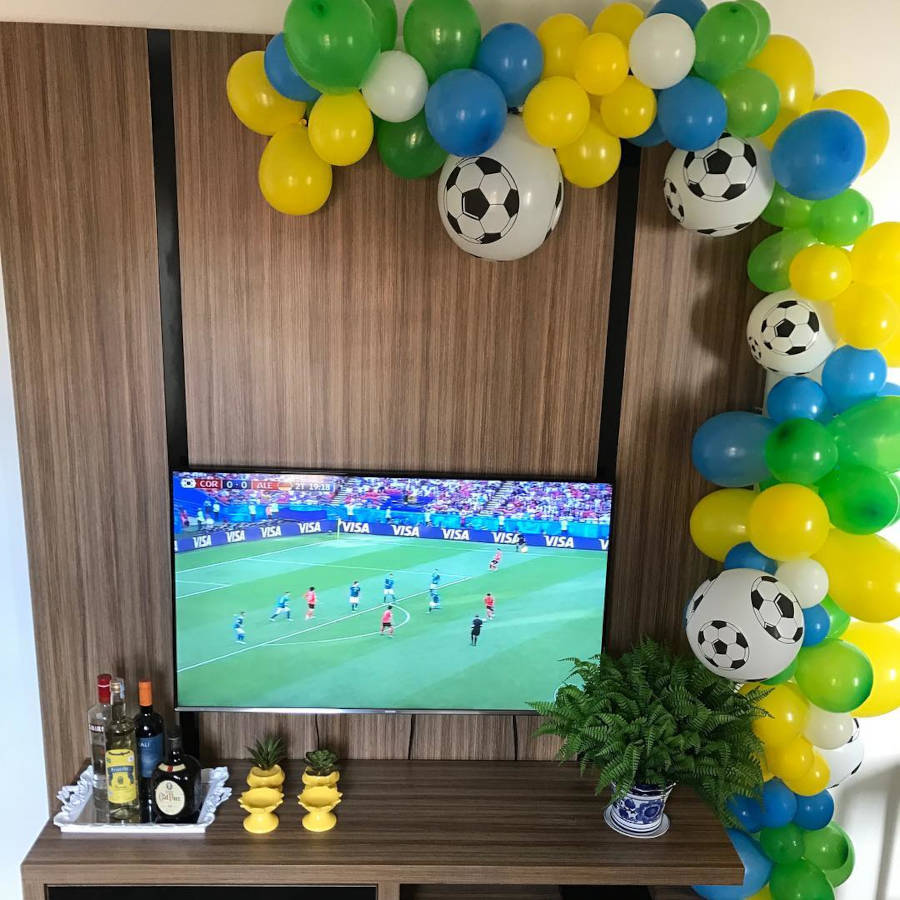 Decoração verde, amarela e azul com bexigas.