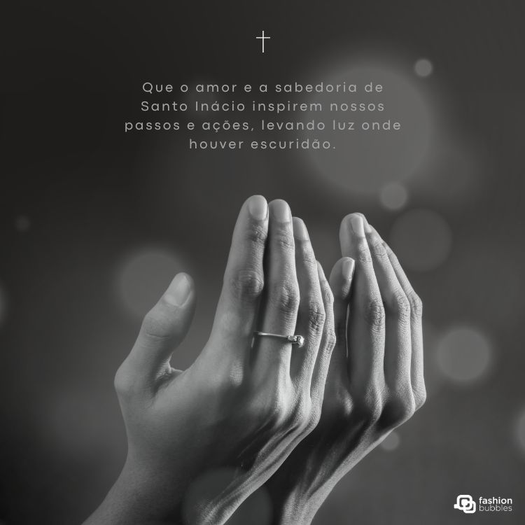 A imagem em preto e branco mostra duas mãos abertas, em oração ou súplica, com um anel no dedo anelar de uma delas. Acima, uma pequena cruz e o texto: "Que o amor e a sabedoria de Santo Inácio inspirem nossos passos e ações, levando luz onde houver escuridão." O logotipo "fashion bubbles" está no canto inferior direito.








