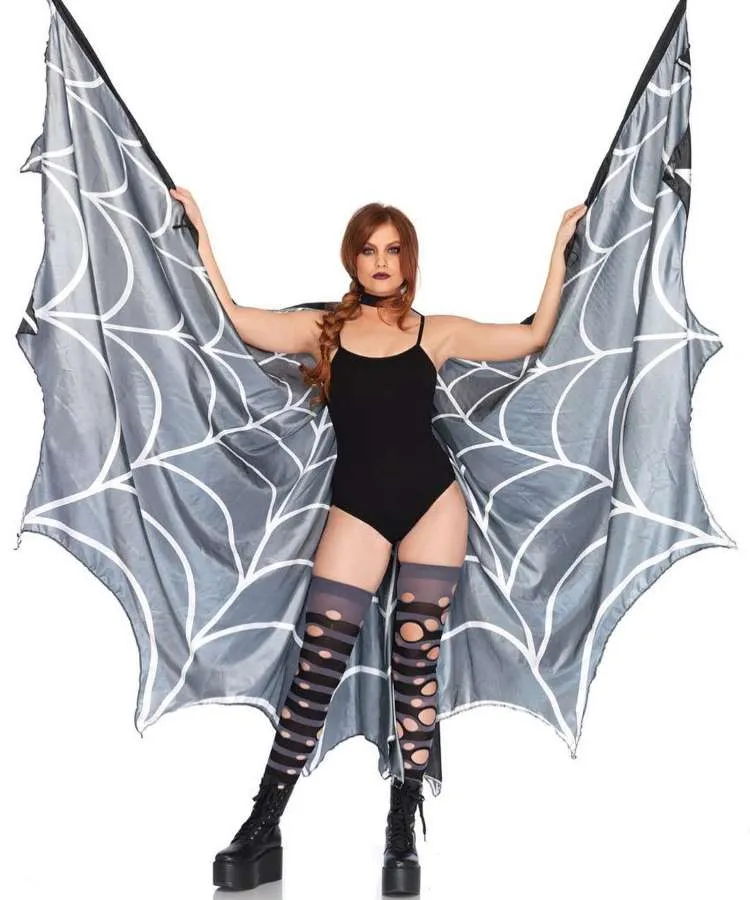 Mulher de pele clara usando body preto, capa de teia de aranha e meias cano longo listradas de  roxo e preto com rasgos 