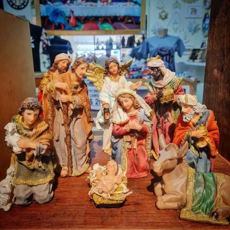 Presépio completo de porcelana com os Três Reis Magos, José, Maria, Jesus, anjos e um burro.