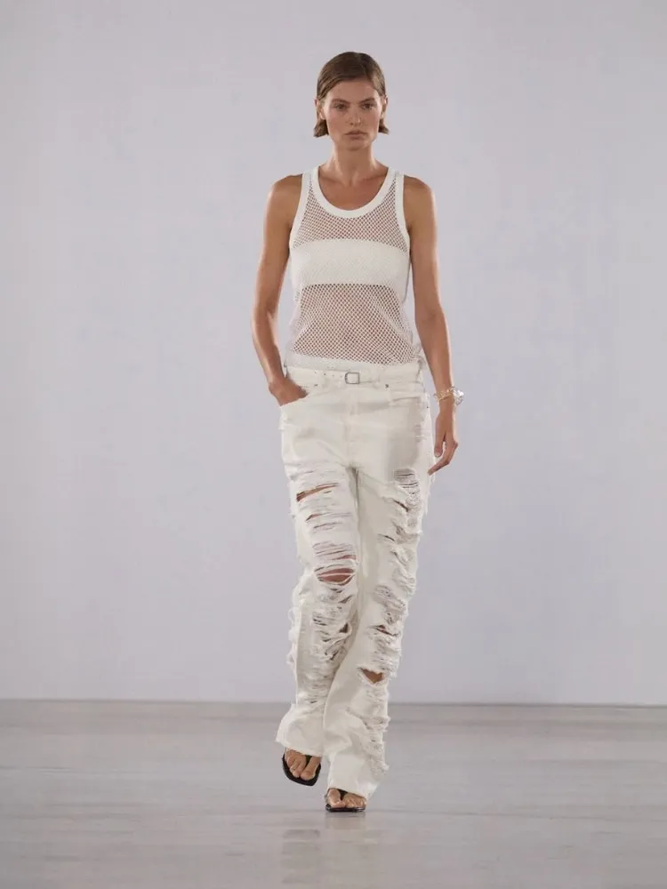 Foto demodelo usando calça jeans destroyed branca da SIMKHAI