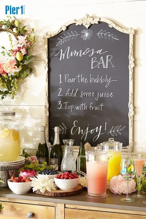 Bar com garrafas de bebidas, jarras de sucos, taças e potes com frutas