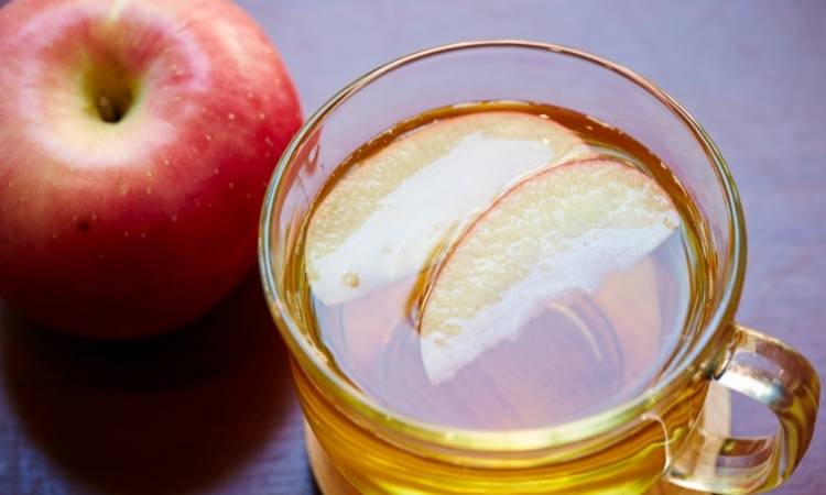 Chá de maçã com pedaços da fruta. Chá com pedaços de maçã.