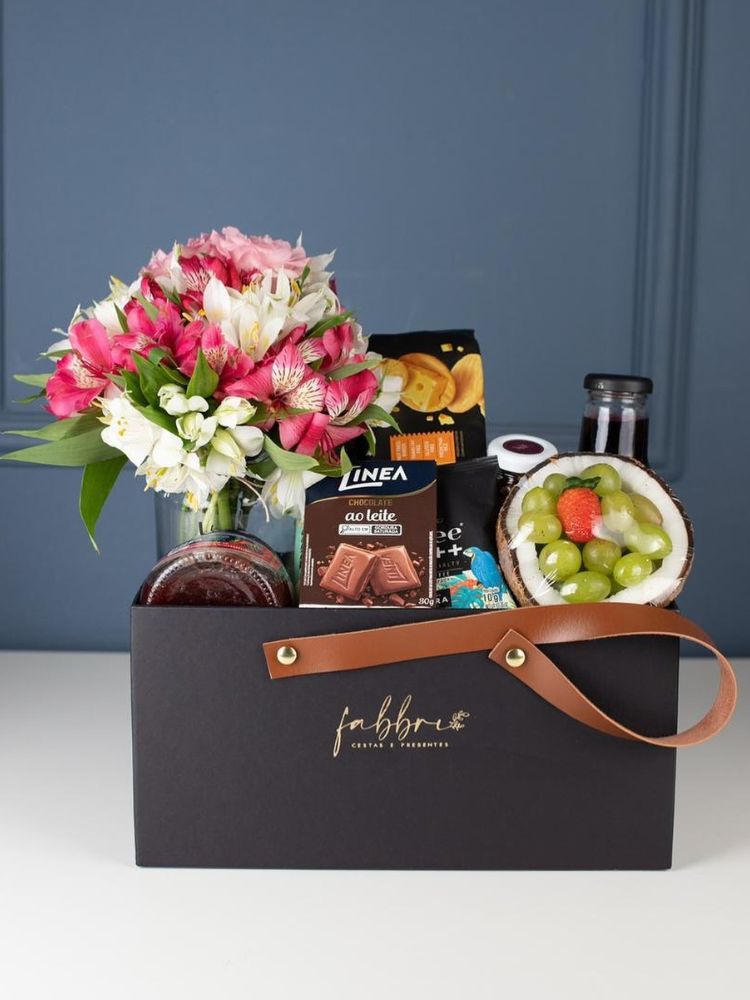 Cesto marrom com flores, uva, morango e doces 