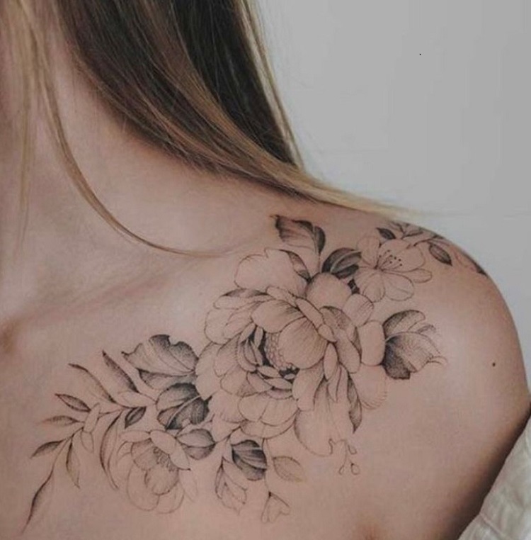 Tatuagem feminina no ombro de flores grandes