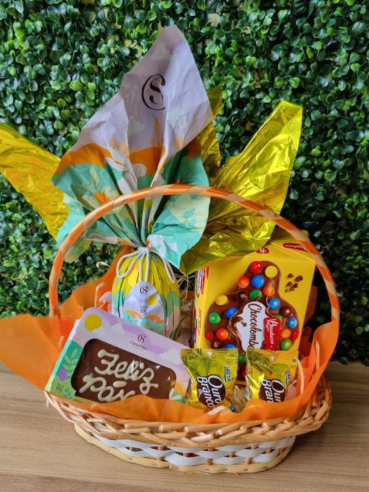 Cesta de Páscoa com ovo, tablete escrito "Feliz Páscoa", bombons e mais 