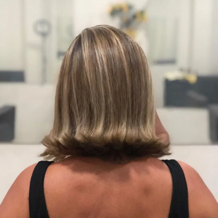 Mulher de pele clara com cabelo chanel com as pontas para fora 