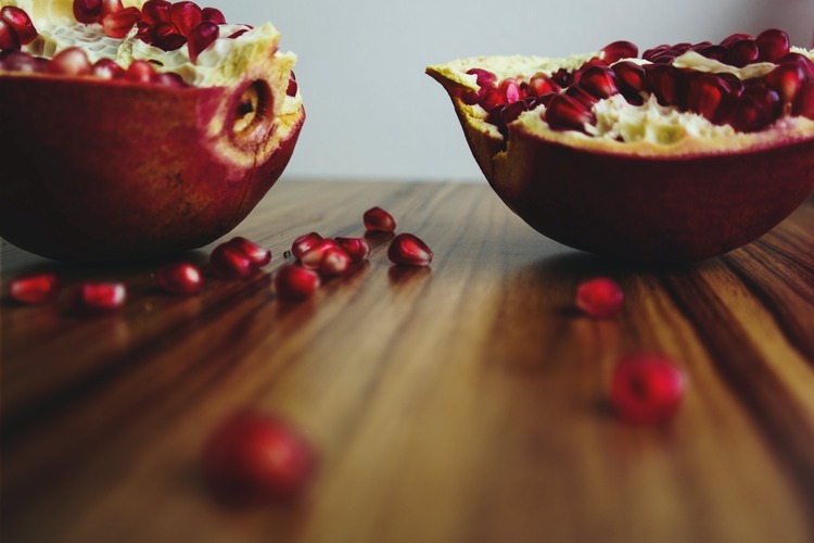 fruta romã aberta, muito utilizada em simpatias de de réveillon, em cima de uma mesa