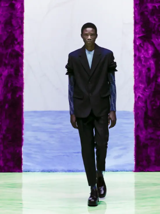 Prada veste modelo com terno e blusa de malha estampada