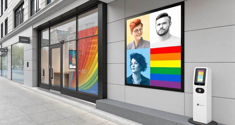 Fachada de loja com design moderno; um display digital exibe retratos coloridos e elementos da bandeira LGBTQIA+. Ao lado, um totem interativo. A vitrine inclui um painel com arco-íris em tons vibrantes, formando um ambiente inclusivo e acolhedor.





