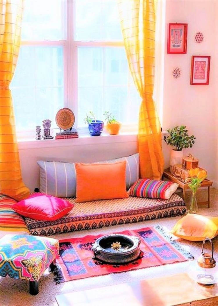 Espaço zen com decoração colorida, como almofadas, colchão, tapete e cortina