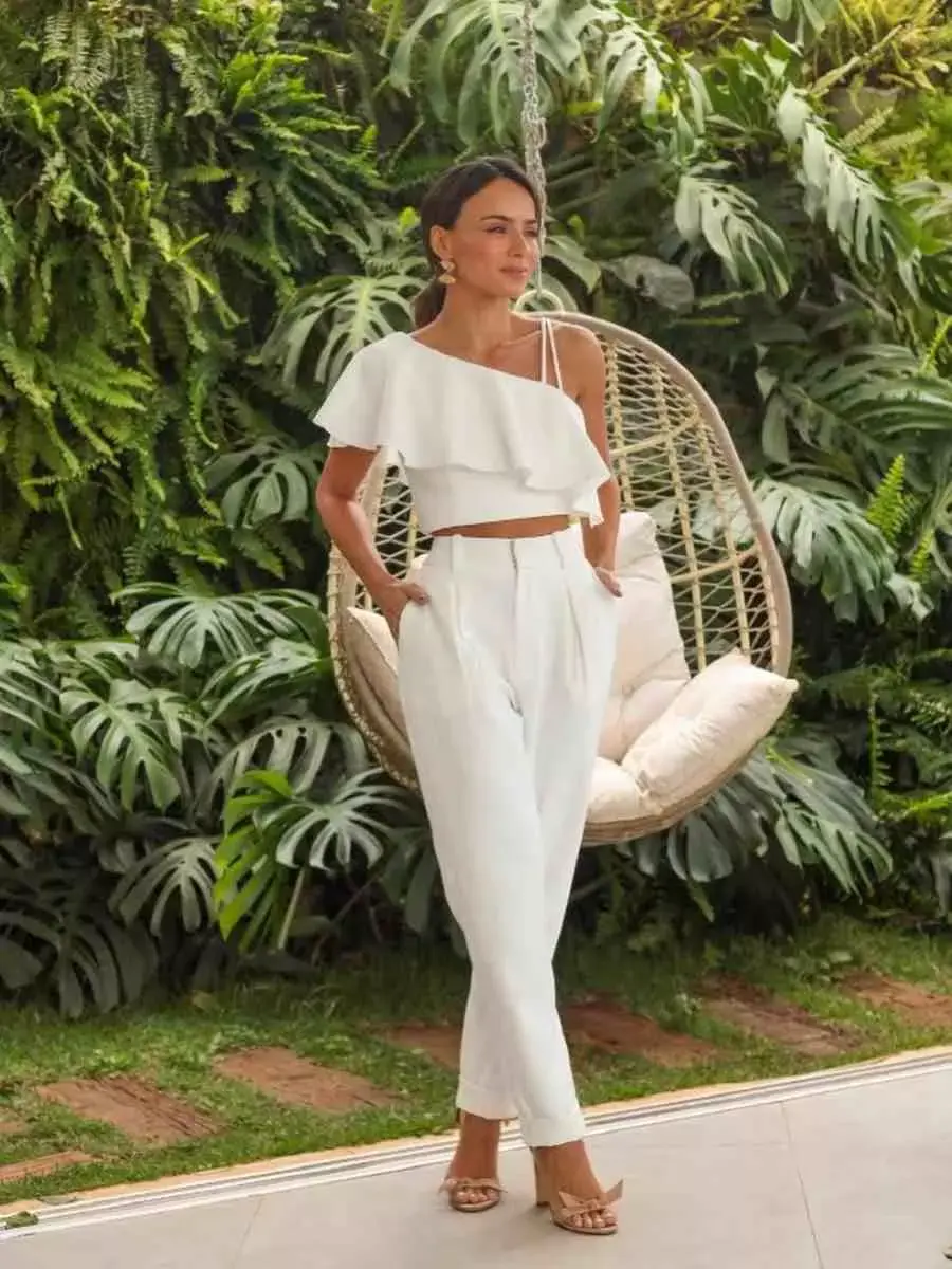 Mulher com look para o Réveillon: cropped branco + calça branca.